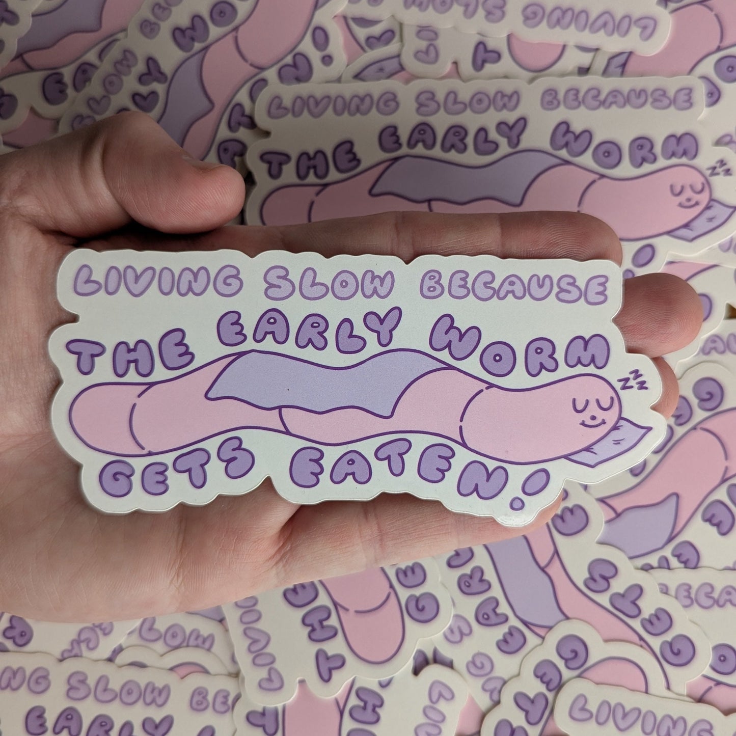 Early Worm Gets Eaten - Meredith Hoagie - Vinyl Stickers Die Cut on laying on top of a hand