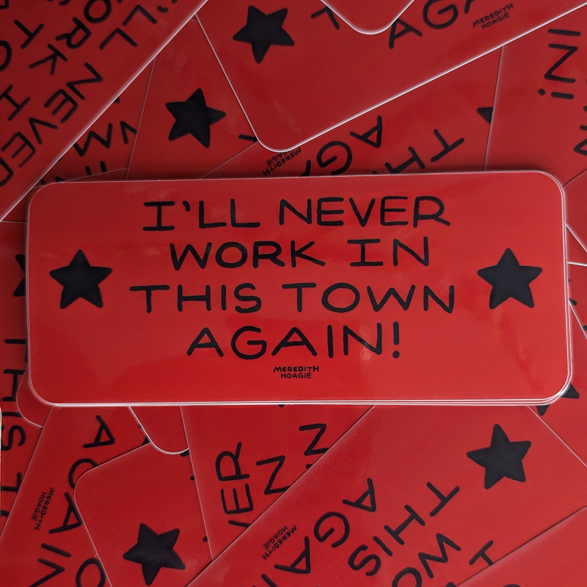 Red stickers with 'I'll Never Work in This Town Again!' text and black stars on a red background by Meredith Hoagie
