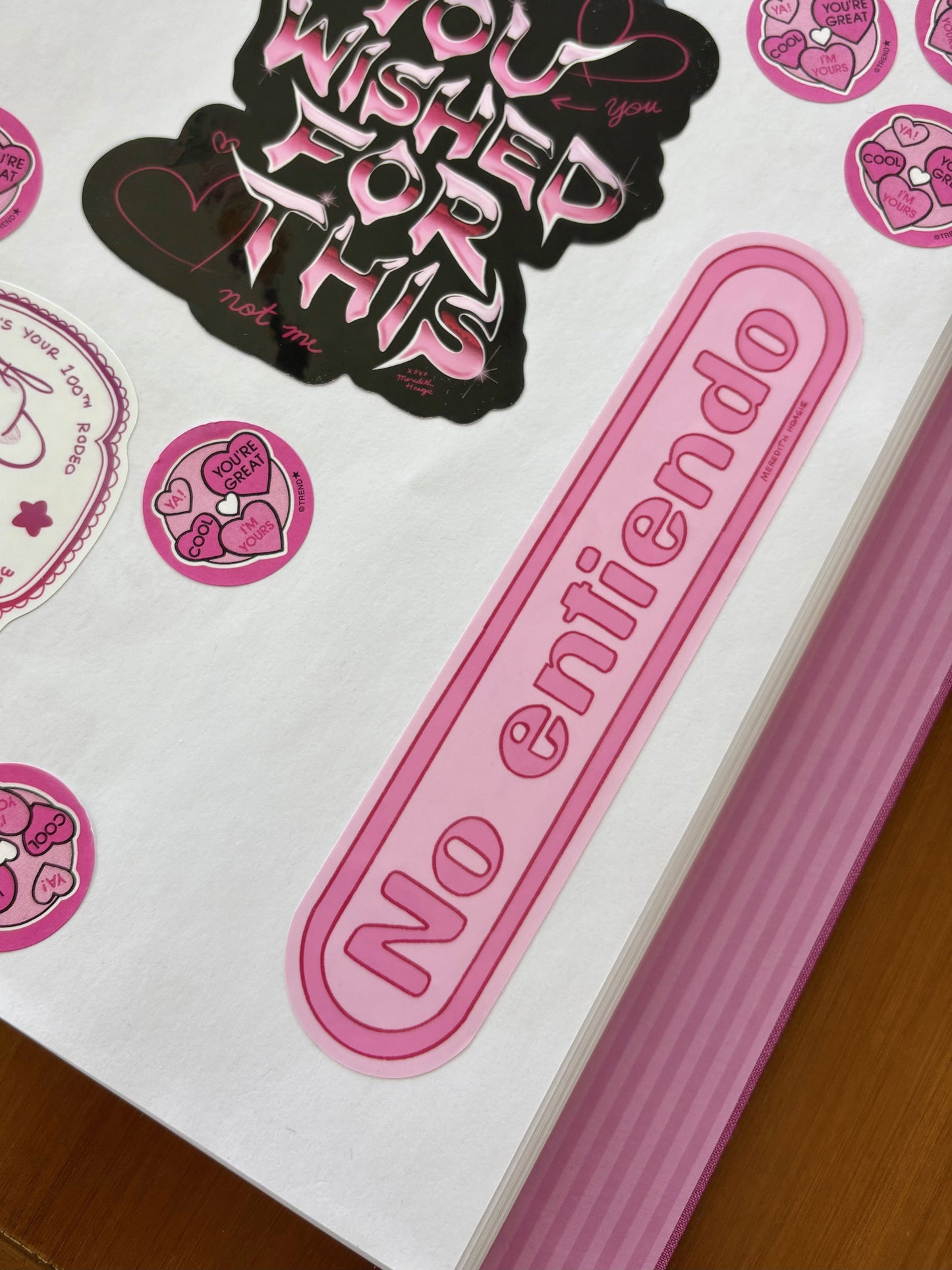 Pink 'No entiendo' sticker on The Coffee Table Sticker Book with other stickers around by Meredith Hoagie