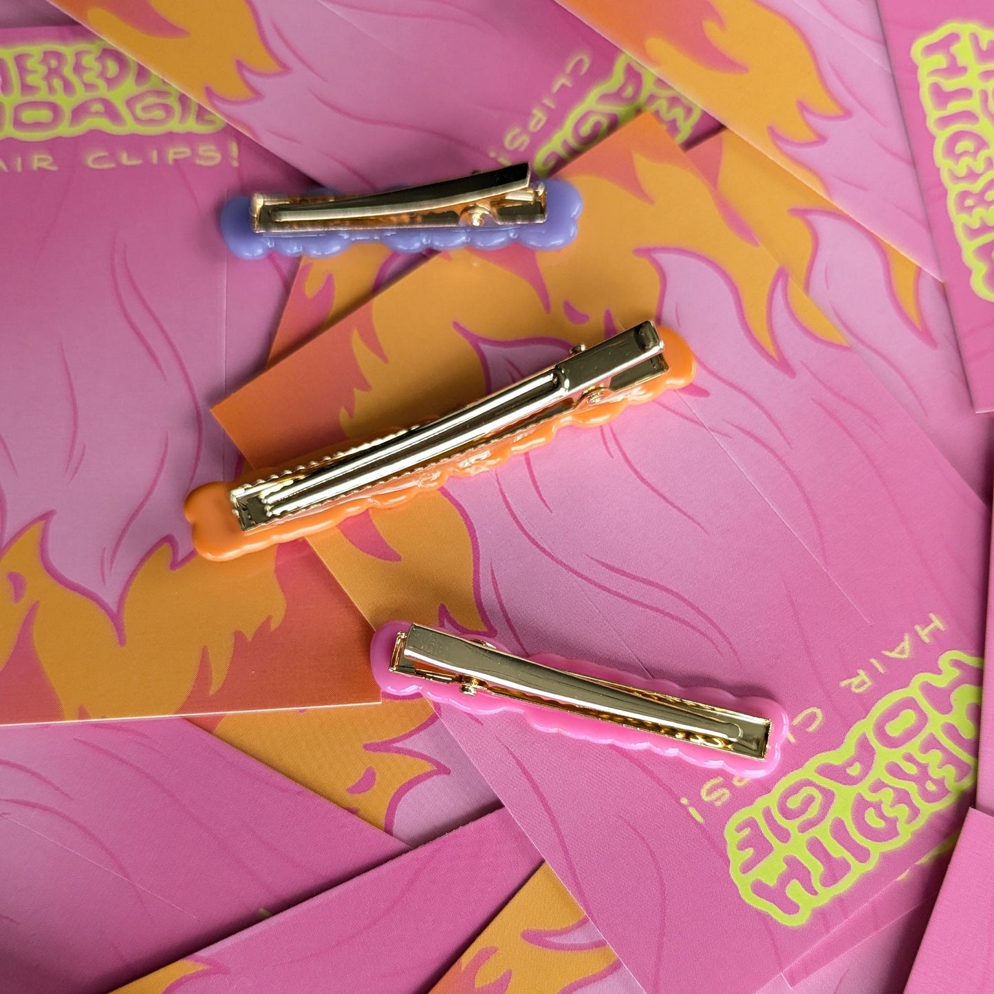 Gold backed upside down hair clips by Meredith Hoagie on pink and yellow patterned cards