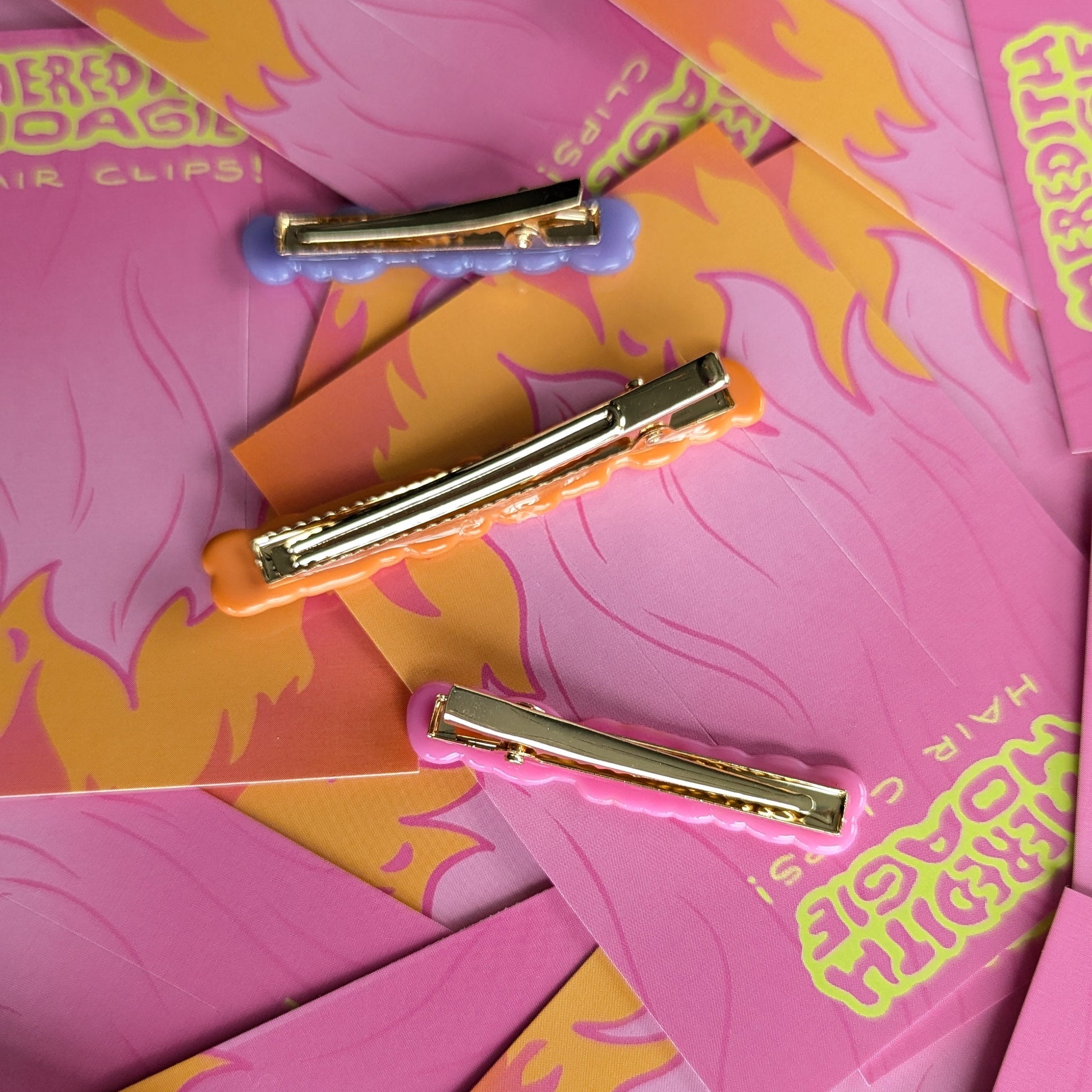 Gold backed upside down hair clips by Meredith Hoagie on pink and yellow patterned cards