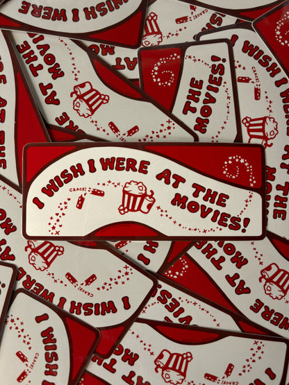 Red and white stickers with 'I Wish I Were at the Movies!' text and graphics by Meredith Hoagie