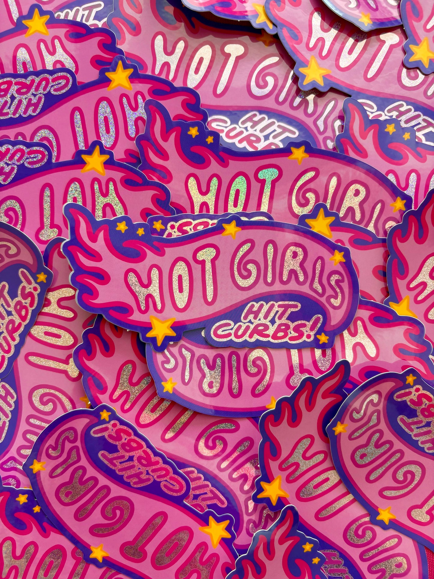 A pile of pink stickers with 'Hot Girls Hit Curbs' design